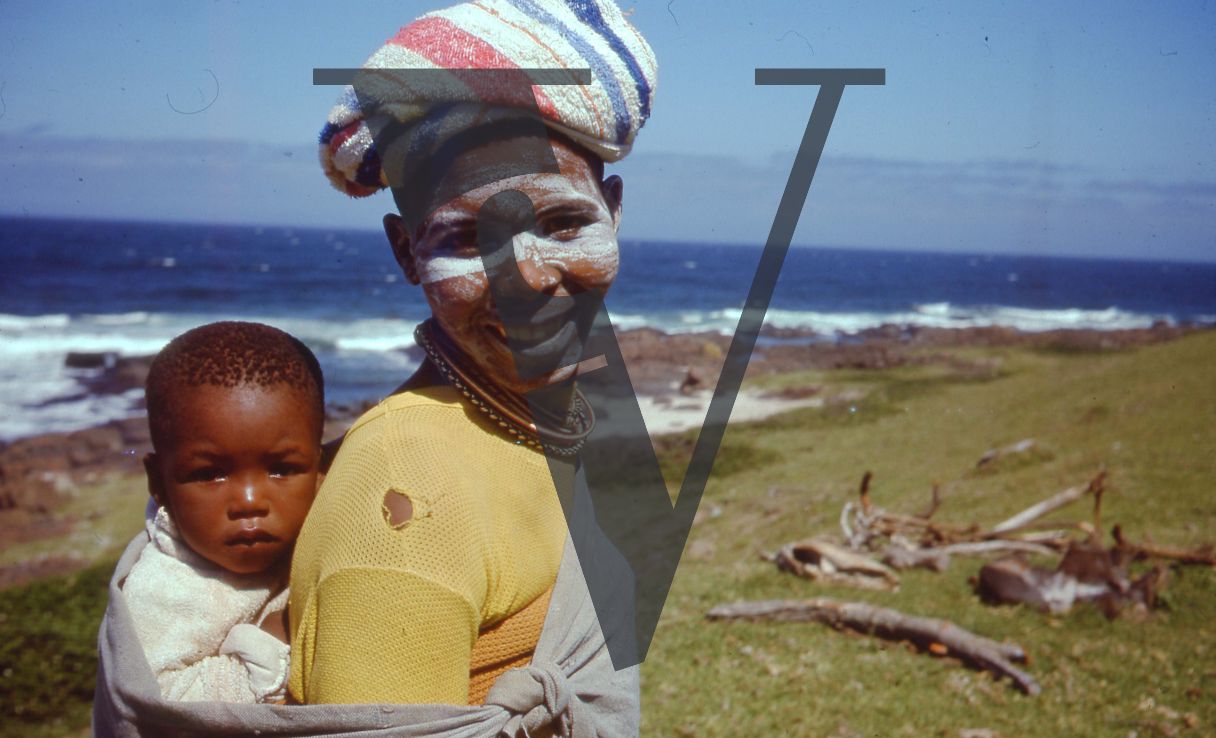 South Africa, Western Cape, coast, woman smiling, young child, painted face, portrait.