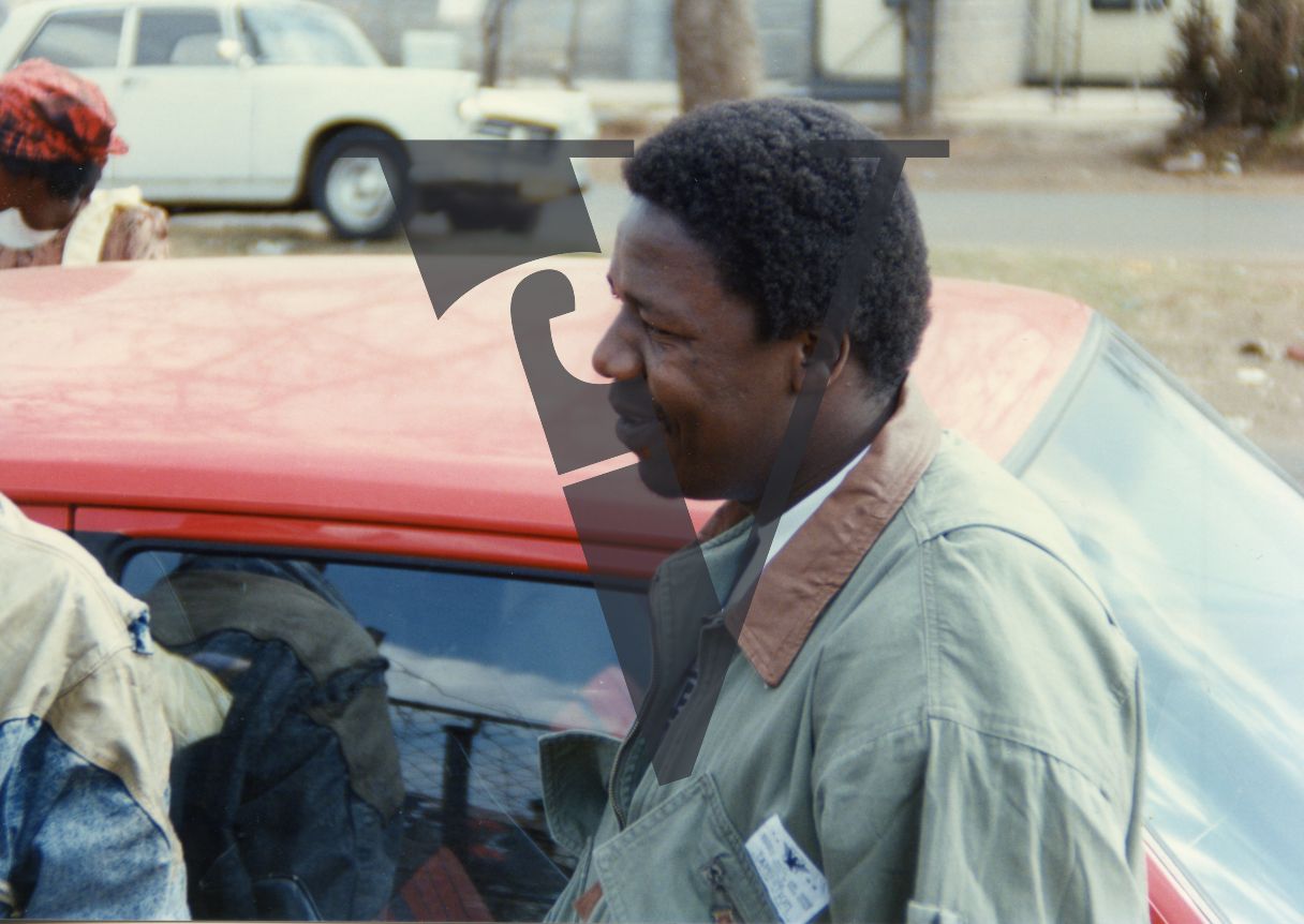 South Africa, Soweto, Peter Ngwenya, playwright, smiling, profile, car.