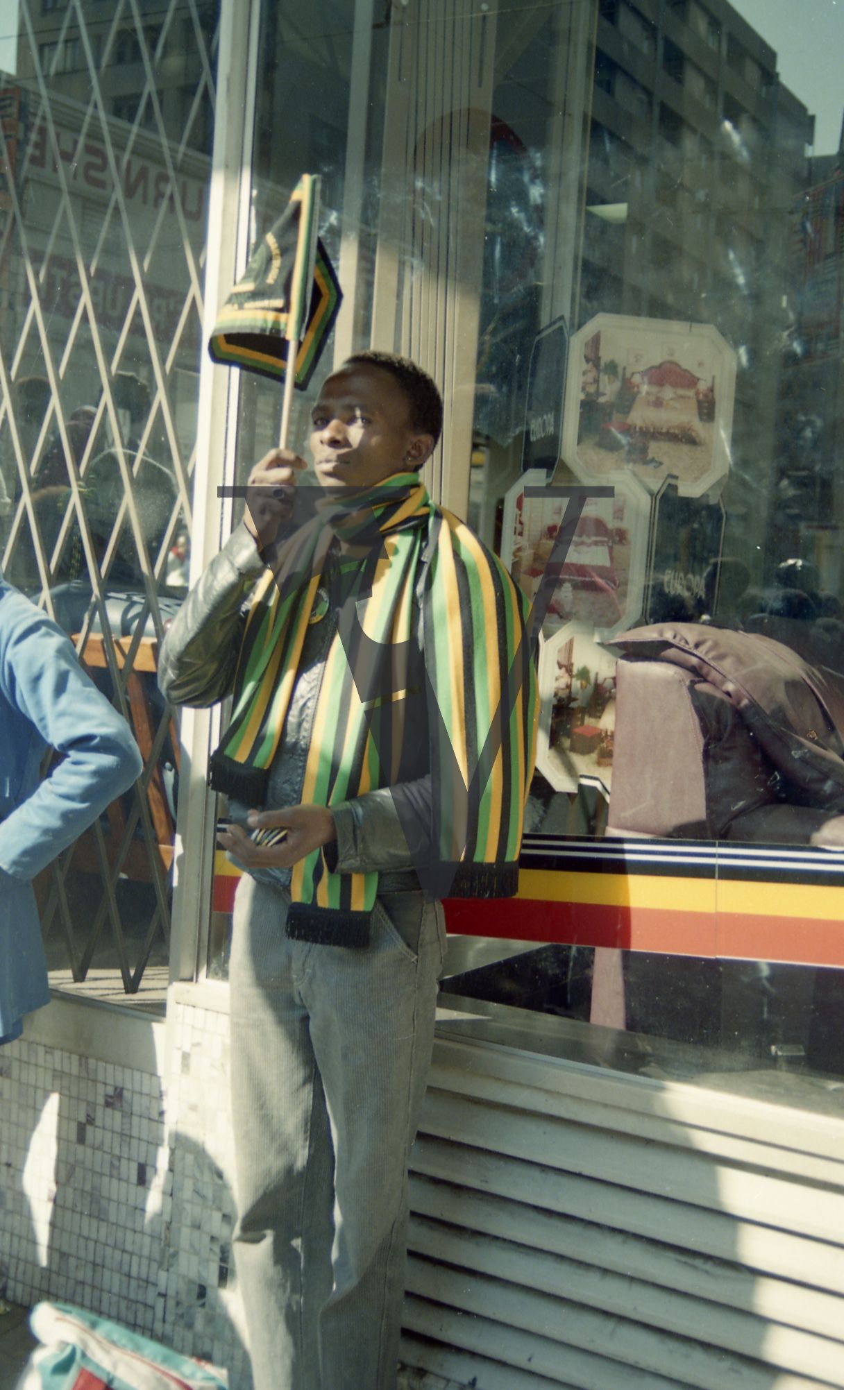 South Africa, street, shop facade, male ANC supporter, flag, figurative.