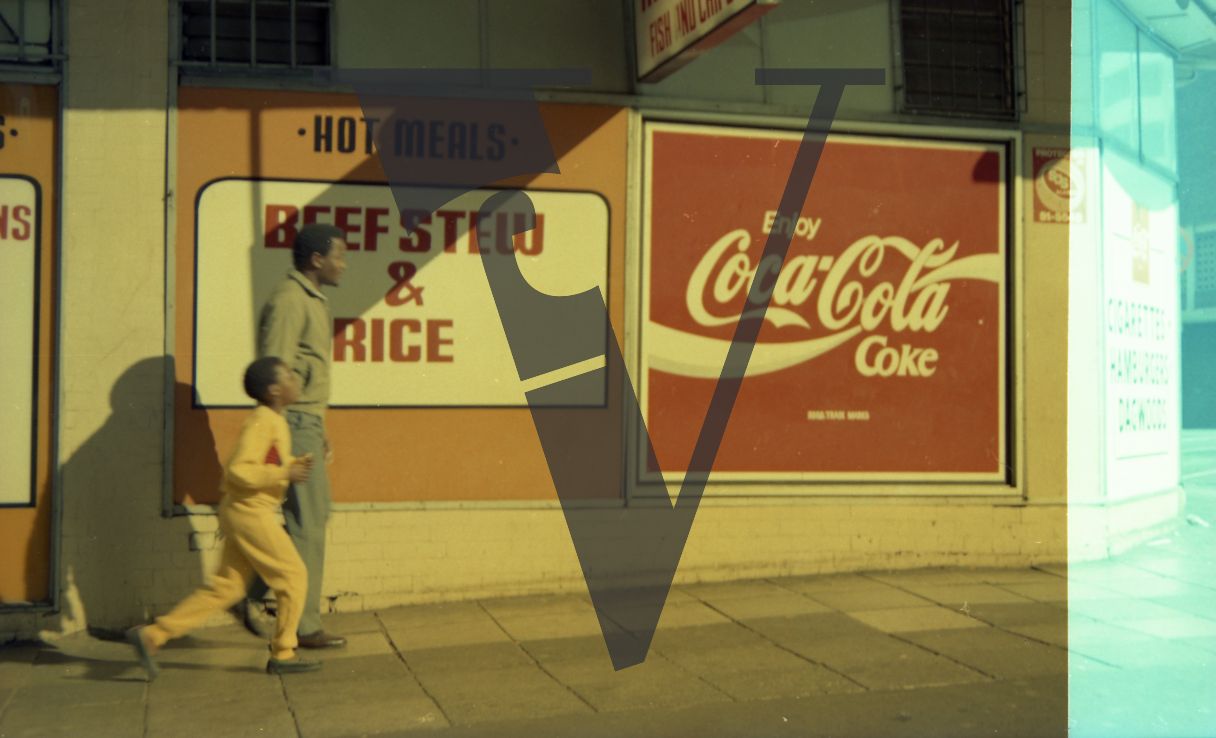 South Africa, street scene, man, boy, profile, Coca-Cola sign.
