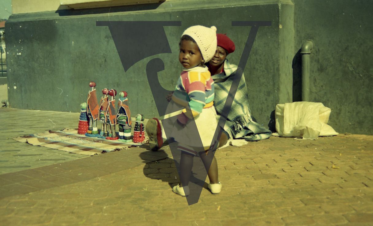 South Africa, Johannesburg, street scene, woman selling dolls, infant.
