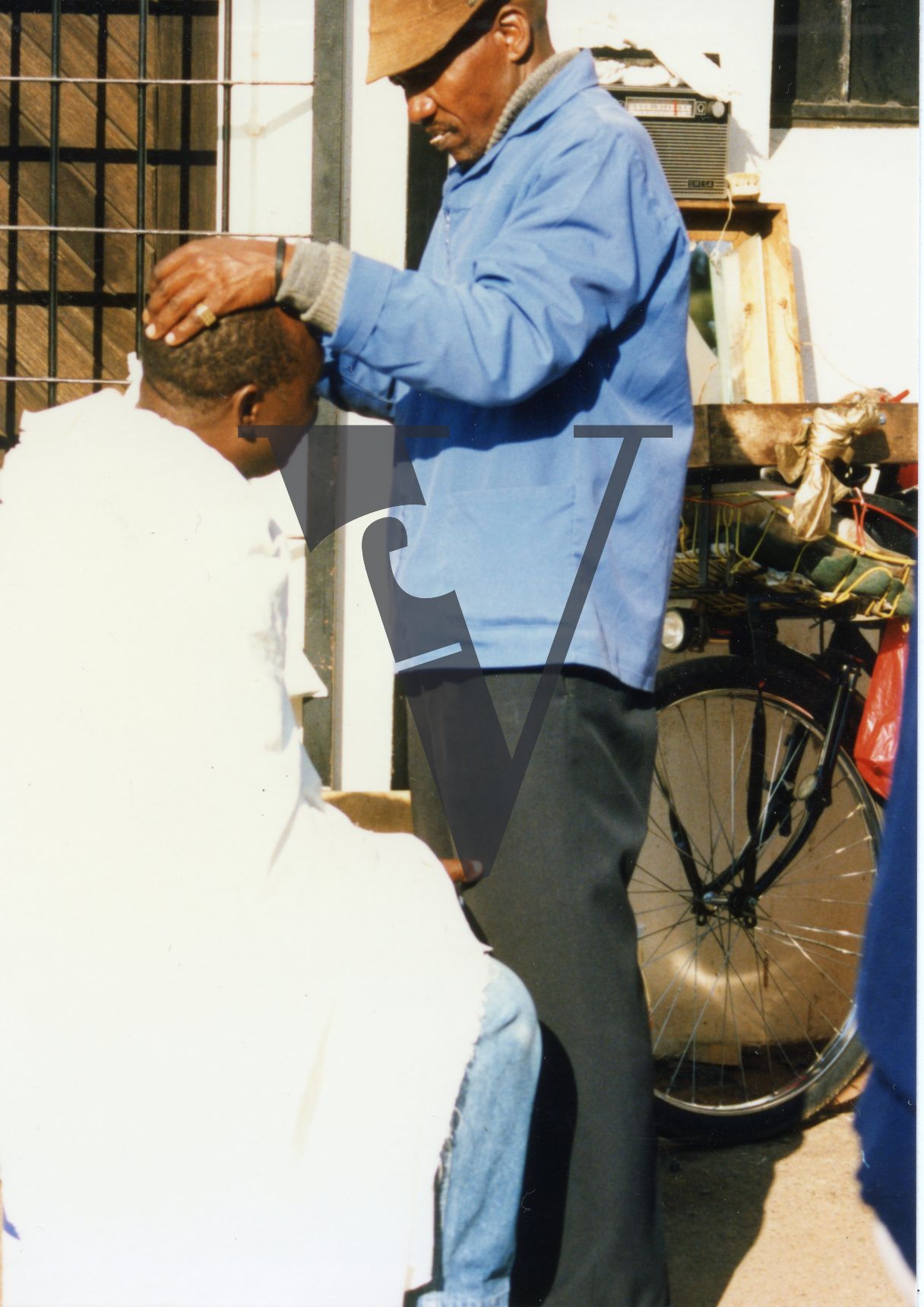 South Africa, man in chair, barber, haircut, exterior.