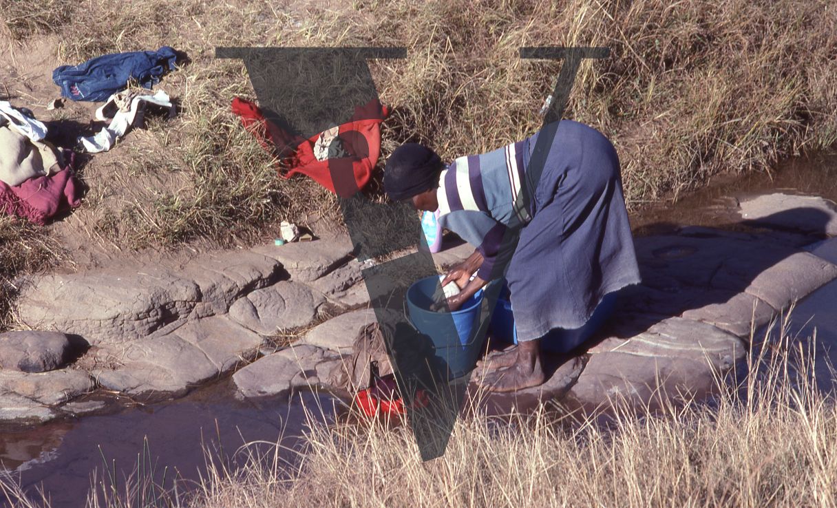 South Africa, Transkei, woman washing clothes in river.
