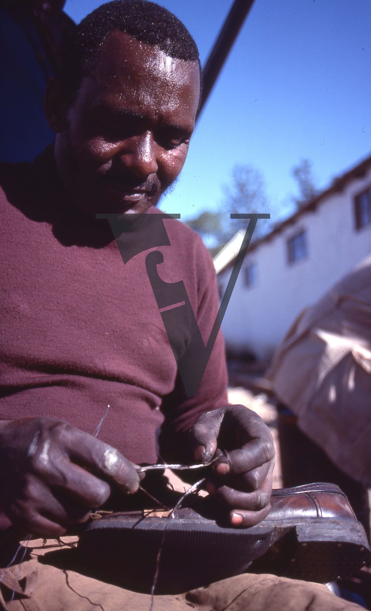 South Africa, Transkei, man repairing shoe, mid-shot.