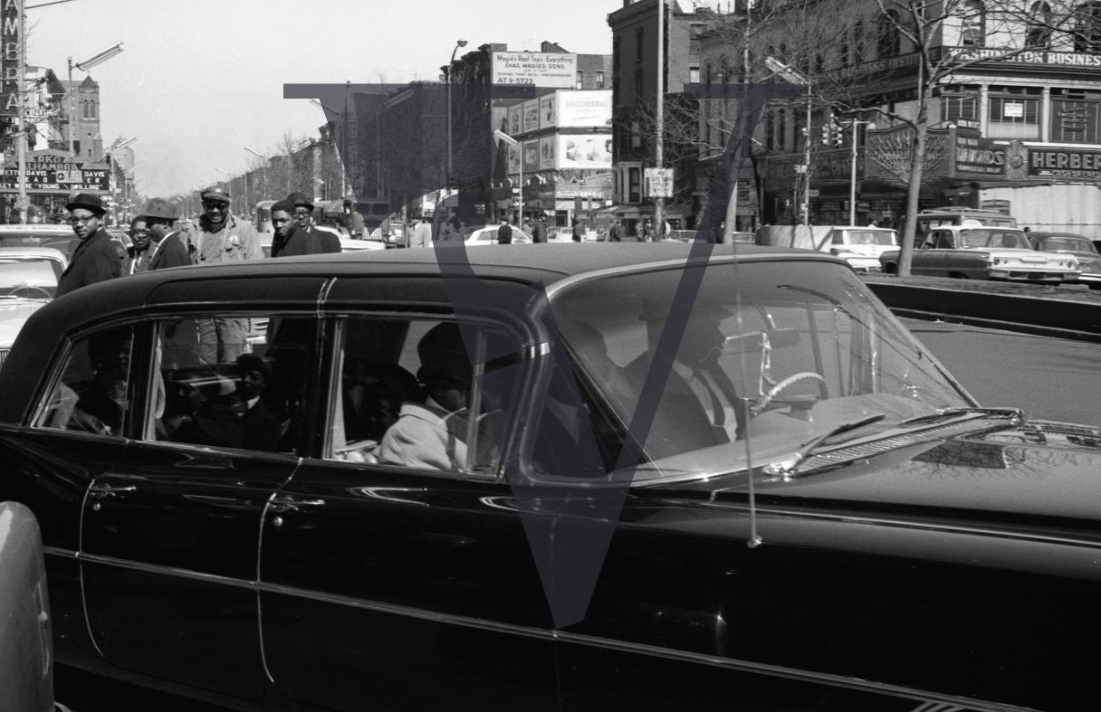 Cassius Clay arrives in Harlem, car driving, Alhambra in background.