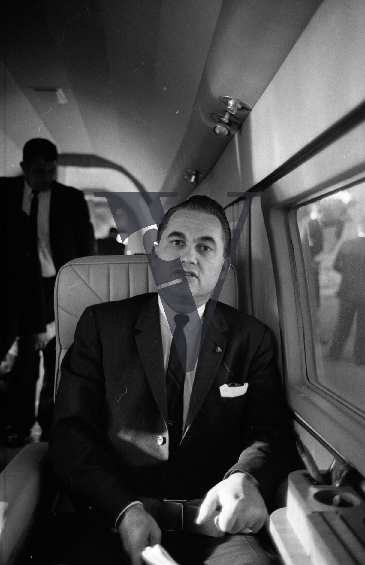 Governor George Wallace, on board plane, portrait, talking.