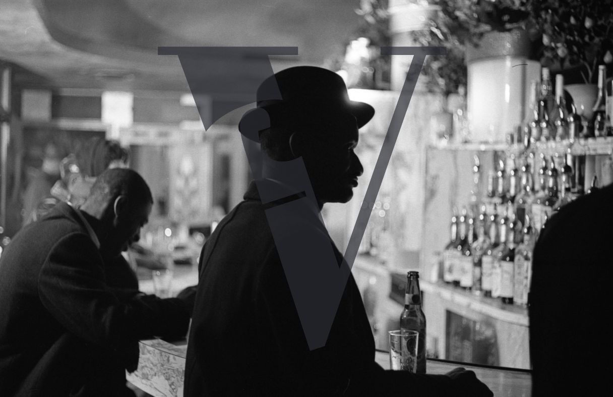 Harlem bar, silhouette, man in hat.