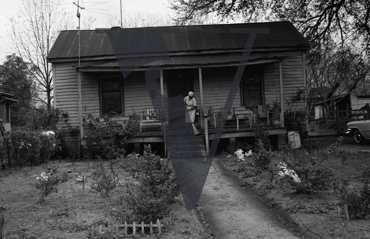Sumter, South Carolina, single house, woman sweeps outside.
