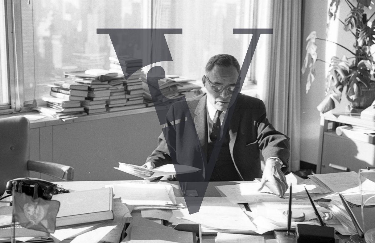 Ralph Bunche, portrait, writing, political scientist, diplomat, organising documents.
