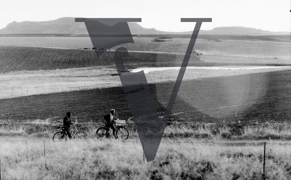Eswatini, two men on bikes, rural.
